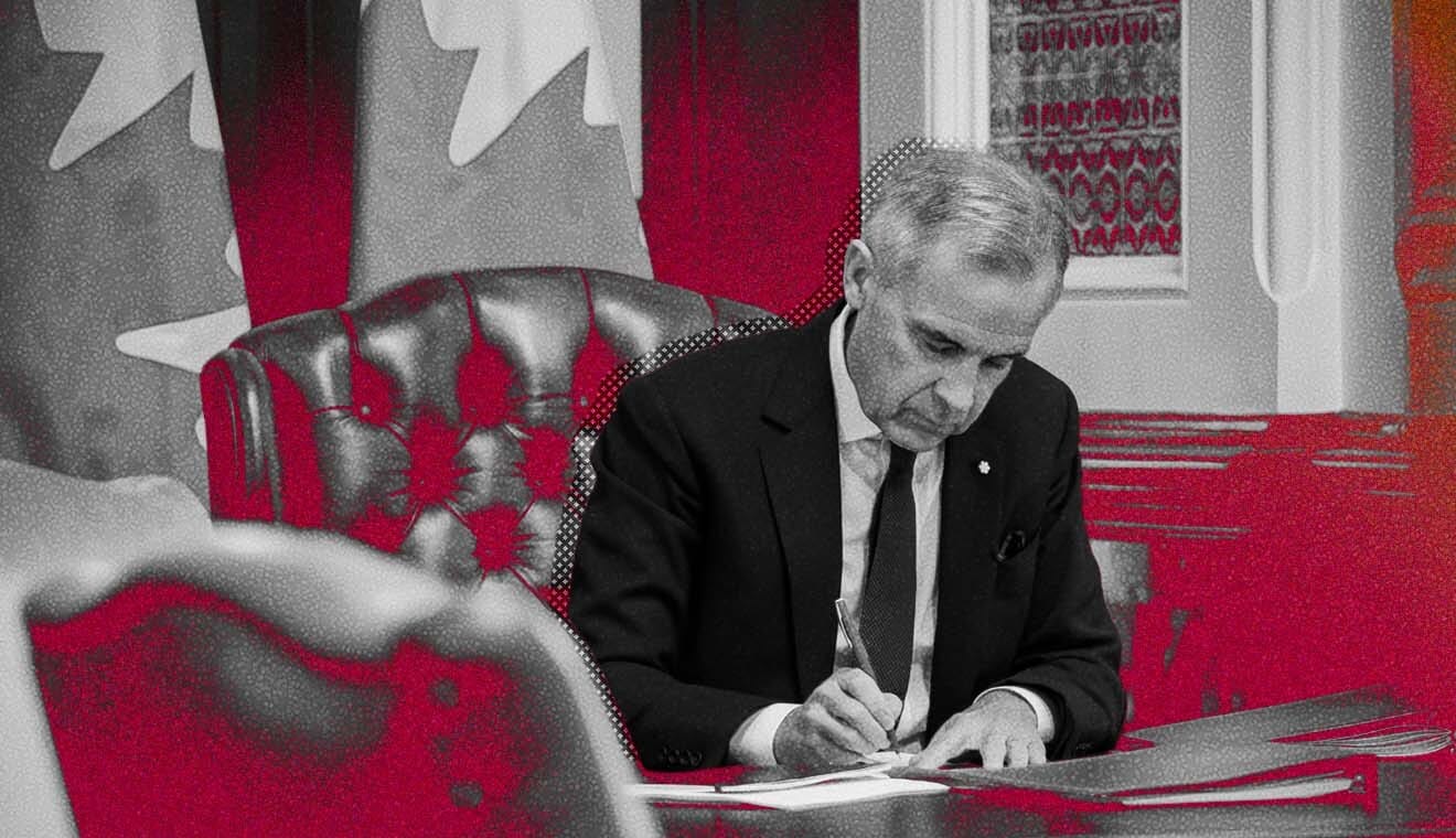 Prime Minister Mark Carney signing documents at a desk.